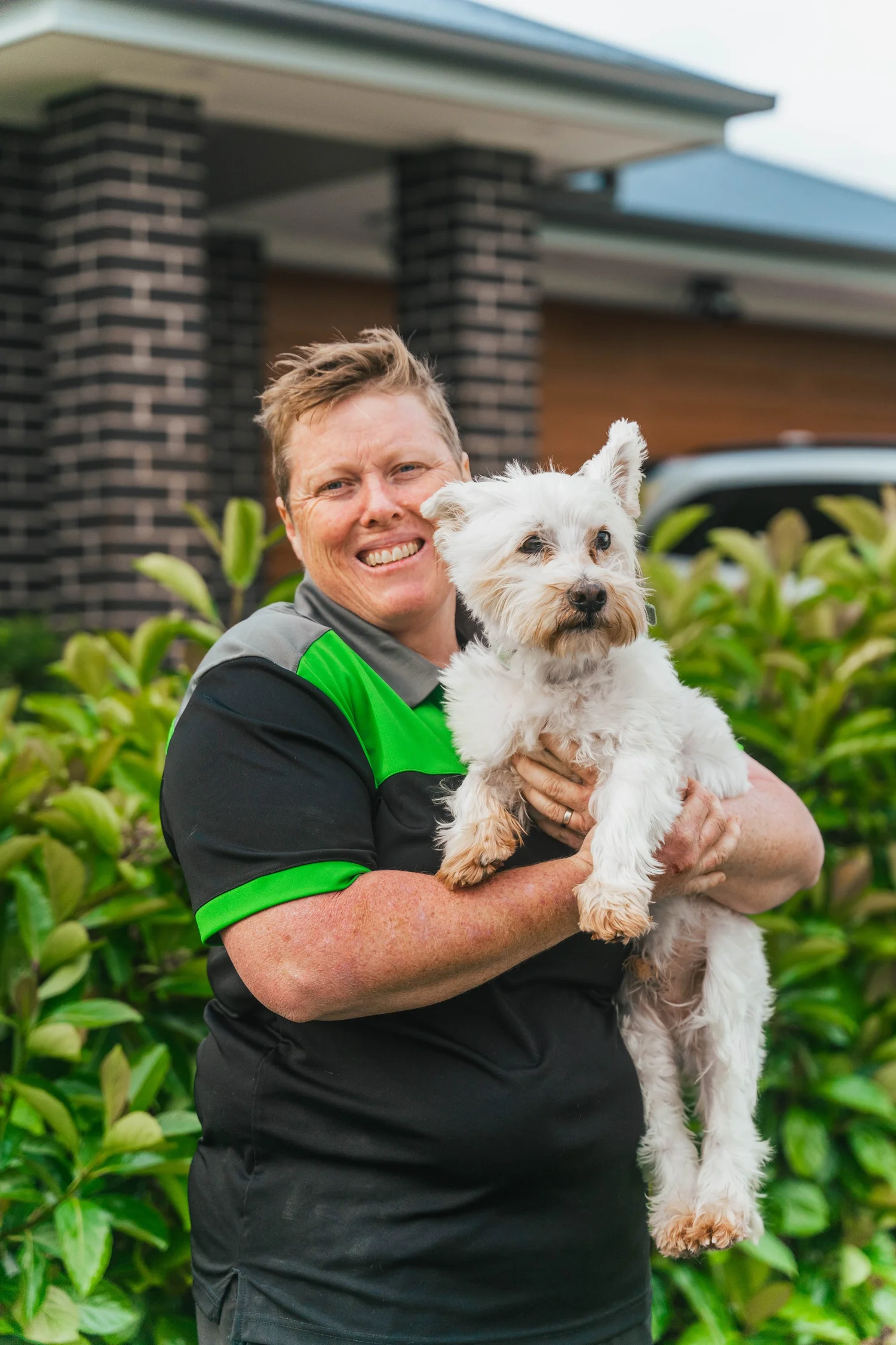 Megan from Pawsome holding a small white dog